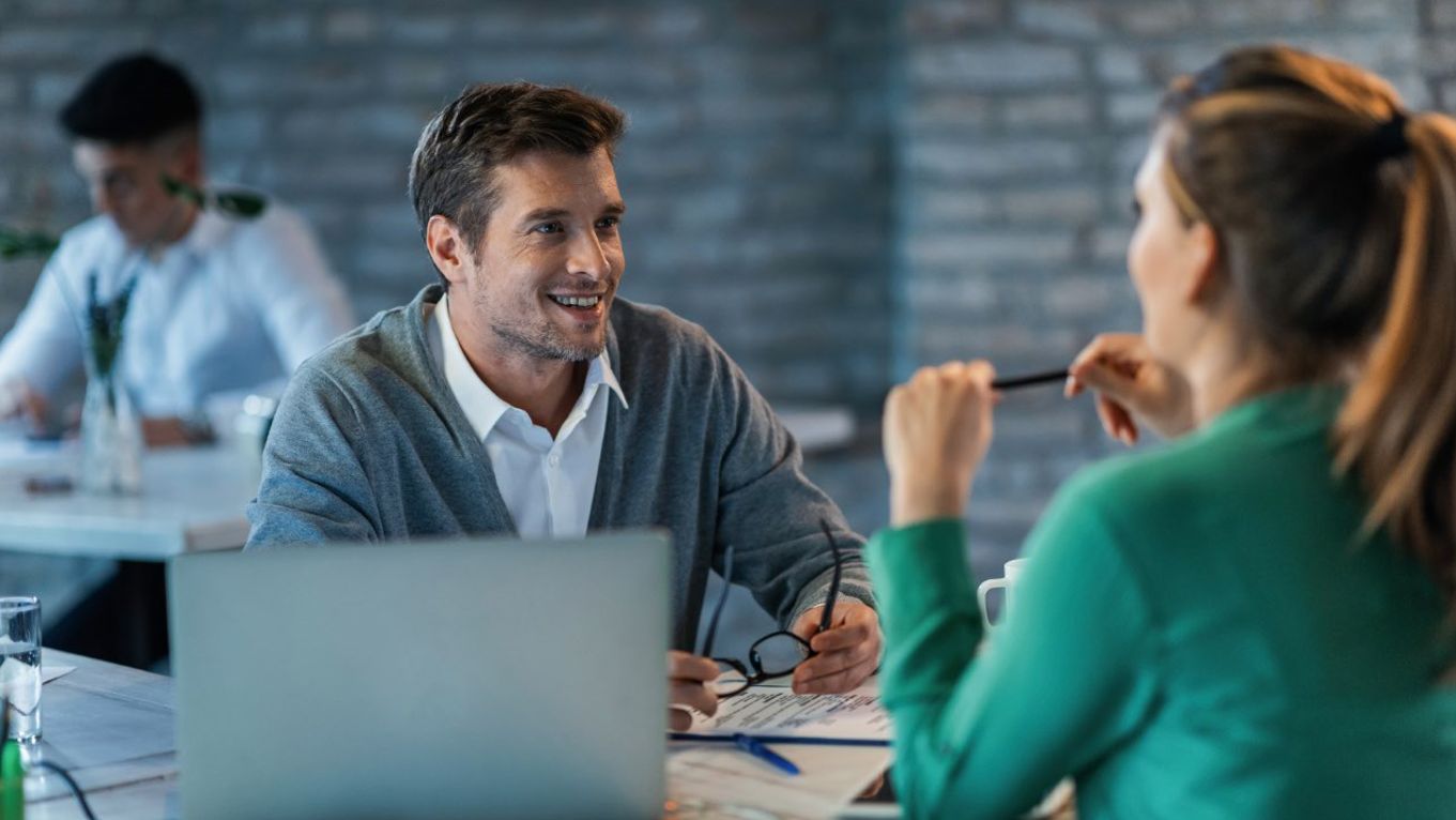 customer centric, profesional hablando con un cliente y sonriendo.